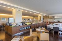 Un restaurante con mesas y un mostrador con un chef. en NAU Morgado Golf & Country Club, en Portimão