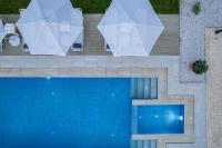 an overhead view of a swimming pool with two umbrellas at Vita Residence, a Charming Family Escape,By ThinkVilla in Pangalochori