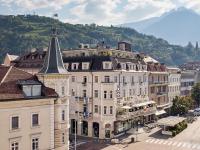 Un gran edificio blanco con una torre encima. en Hotel Europa Splendid, en Merano