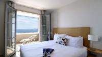 a bedroom with a bed with a view of the ocean at Hôtel La Villa Douce in Rayol-Canadel-sur-Mer