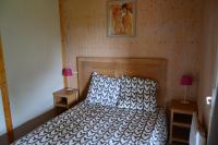 a bedroom with a bed with a wooden headboard and two lamps at Beautiful lake view 3 bedroom chalet. in Saint-Manvieu-Bocage