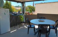 a patio with a table and chairs and a refrigerator at Chambres d&#39;hôtes &amp; jacuzzi - A l&#39;ombre des amandiers in Saint-Martin-dʼArdèche