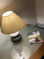 a lamp sitting on a table next to a magazine at Hôtel les Platanes in Villeneuve-sur-Lot