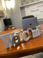 a sign that says new on a desk with a laptop at Hôtel les Platanes in Villeneuve-sur-Lot