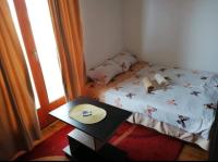 a small bedroom with a bed and a table at Apartman Elena in Vrnjačka Banja