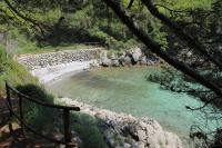 a body of water with rocks and a bench at Double Room Krk 5294b in Krk