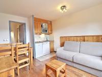 a living room with a couch and a kitchen at Appartement La Tania, 2 pièces, 4 personnes - FR-1-182A-26 in Courchevel