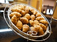 Una cesta llena de croissants sobre un mostrador. en Anjum Makkah Hotel, en La Meca
