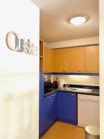 a kitchen with blue counters and wooden cabinets at Appartement 2 chambres vue pistes, parking privatif in Les Orres