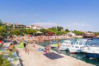 a group of people on a beach with boats in the water at Apartments with a parking space Sveti Petar, Biograd - 6169 in Sveti Petar