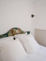 a white bed with white pillows and a headboard at La Maison Pieuse in Villiers-Saint-Benoît