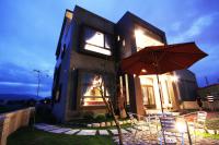 a house with a table and an umbrella in front of it at Weiden House in Luodong