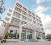 a large white building with windows on the side of it at Hotel Agnes in Buriram
