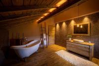 a large bathroom with a tub and a wooden floor at Le 11 des Bouchaux, Gîte d&#39;exception in La Bresse