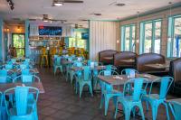 un ristorante con tavoli di legno e sedie blu di Rivers Rest Resort a Mount Airy