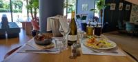 a table with bottles of wine and a plate of food at Dali Hôtel Perpignan - Restaurant in Perpignan