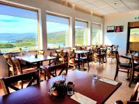 BrjánslækurにあるHótel Flókalundurのテーブルと椅子と大きな窓のあるレストラン