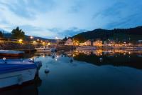 a marina at night with boats in the water at HOTEL de la Truite &amp; SPA Le petit Nautilus in Le Pont