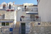 a building with balconies and a person on a balcony at Apartment Jezera 5057b in Jezera