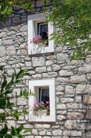 two windows on a stone wall with flowers in them at Apartment Jezera 5057b in Jezera