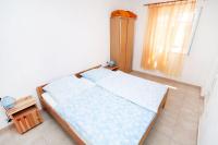 a small bedroom with a bed and a window at Apartment Jezera 5057b in Jezera