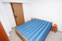 a bed with a blue sheet in a room at Apartment Jezera 5057b in Jezera