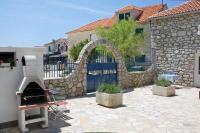 an outdoor patio with a stone fence and an oven at Apartment Jezera 5057b in Jezera