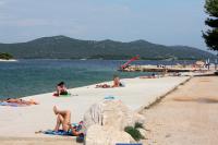 a group of people laying on a beach at Apartment Jezera 5057b in Jezera