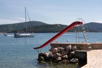 a red slide in the water with a boat at Apartment Jezera 5057b in Jezera
