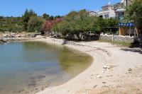 a beach with a body of water next to a building at Apartments with a parking space Grebastica, Sibenik - 13365 in Bašelovići