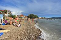 un groupe de personnes sur une plage près de l&#39;eau dans l&#39;établissement Apartments by the sea Sukosan, Zadar - 5905, à Sukošan