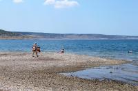 a man standing on a beach near the water at Apartment Seline 11197b in Starigrad