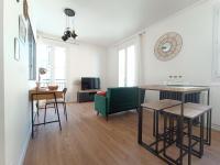 a living room with a table and a green couch at L&#39;Atelier d&#39;Oscar in Le Havre