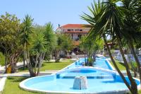 a large swimming pool with palm trees in a resort at Skiathos Holiday Resort in Skiathos