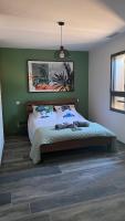 a bedroom with a bed with a green wall at LES ROCHES DE BAUDISSET in Saint-Paul-en-Forêt