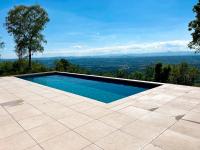 a swimming pool with a view of the mountains at Bienvenue au Mas du Roulier, villa provençale avec vue hypnotique sur la chaine des Puys in Thiers