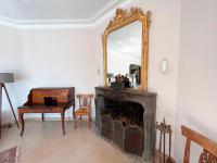 a living room with a mirror and a fireplace at Bienvenue au Mas du Roulier, villa provençale avec vue hypnotique sur la chaine des Puys in Thiers