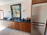 a kitchen with a stainless steel refrigerator and a sink at Bienvenue au Mas du Roulier, villa provençale avec vue hypnotique sur la chaine des Puys in Thiers