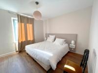 a bedroom with a white bed and a window at Bienvenue au Mas du Roulier, villa provençale avec vue hypnotique sur la chaine des Puys in Thiers