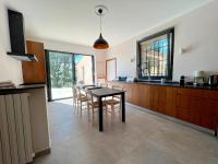 a kitchen with a table and chairs in a room at Bienvenue au Mas du Roulier, villa provençale avec vue hypnotique sur la chaine des Puys in Thiers