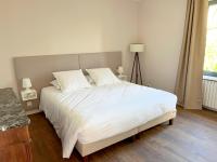 a bedroom with a large bed with white sheets at Bienvenue au Mas du Roulier, villa provençale avec vue hypnotique sur la chaine des Puys in Thiers