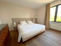 a bedroom with a large white bed and a window at Bienvenue au Mas du Roulier, villa provençale avec vue hypnotique sur la chaine des Puys in Thiers