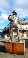 a statue of a baseball player standing in the street at LE GALOPIN Etaples le Touquet in Étaples