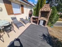 a patio with a grill and chairs and a table at LE GALOPIN Etaples le Touquet in Étaples