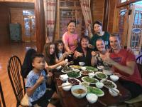 Un grupo de personas sentadas alrededor de una mesa comiendo comida en Sau Meo Mountain View, en Sa Pa