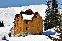 a large wooden building with snow on the roof at Smerichka Hotel in Dragobrat