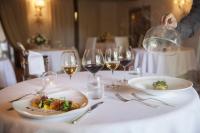 a table with a plate of food and wine glasses at Relais La Corte dei Papi in Cortona