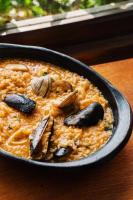 蒙塔尼塔Hotel Kundalini的桌子上放着一碗米饭，里面有蘑菇和贝类。