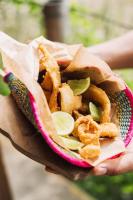 蒙塔尼塔Hotel Kundalini的一个人手里拿着一篮炸物和几片青柠。