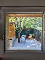 a window view of a patio with a table and a tree at Charmant logement avec parking in Orvault